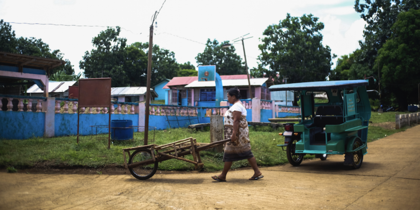 A woman pushes a wooden cart used to carry water containers in Salcedo, Eastern Samar (Photo: Jed Regala/Oxfam)